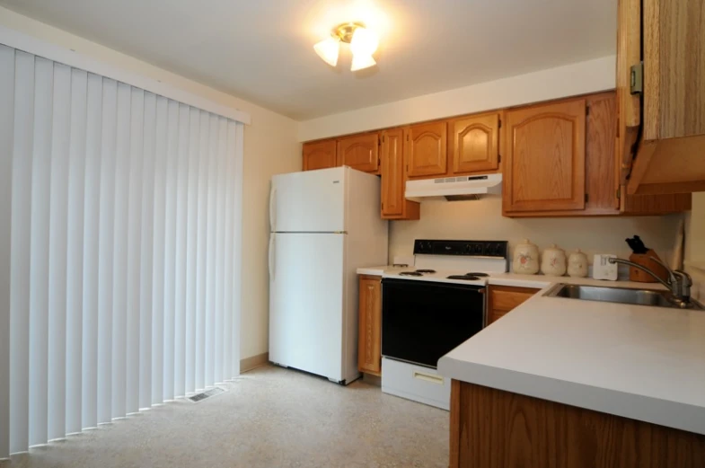 a kitchen with a white refrigerator freezer and stove