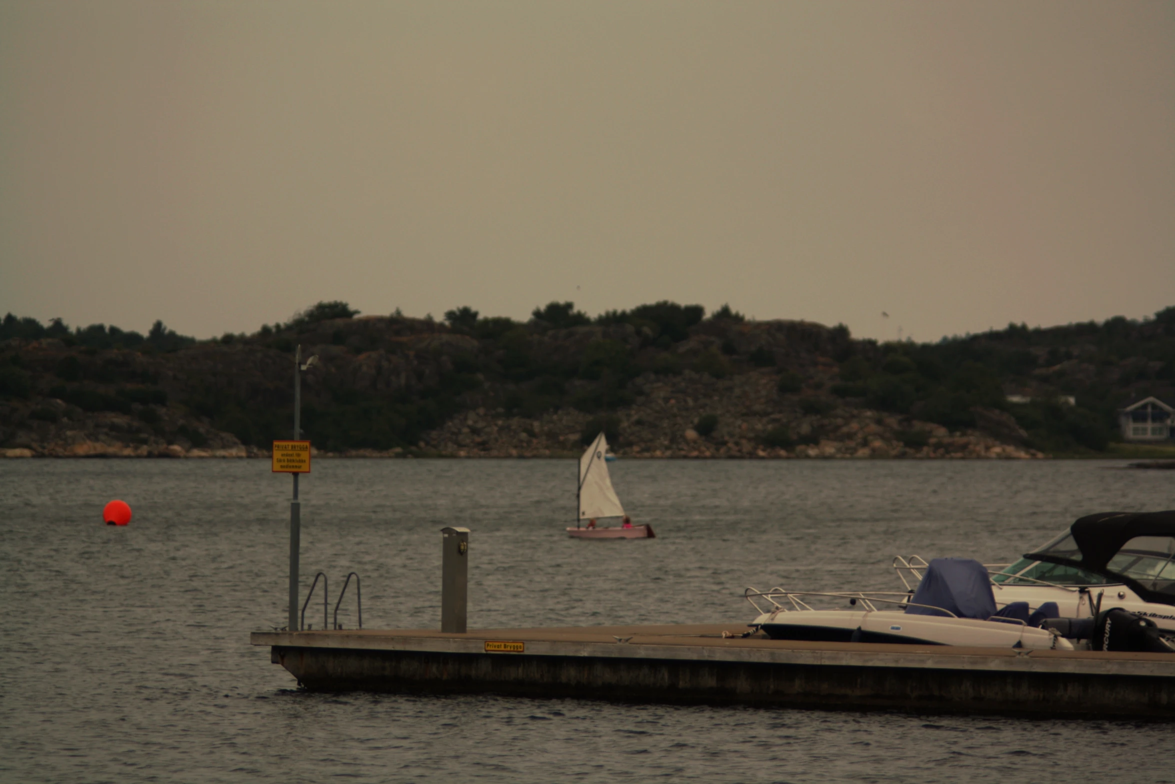 two boats docked next to a dock with a boat