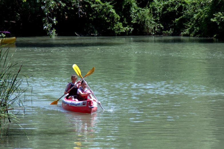 a man and woman in a kayak on the water