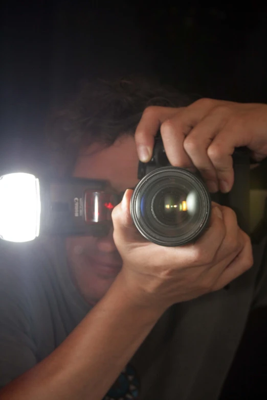 a man taking a picture with a camera at night