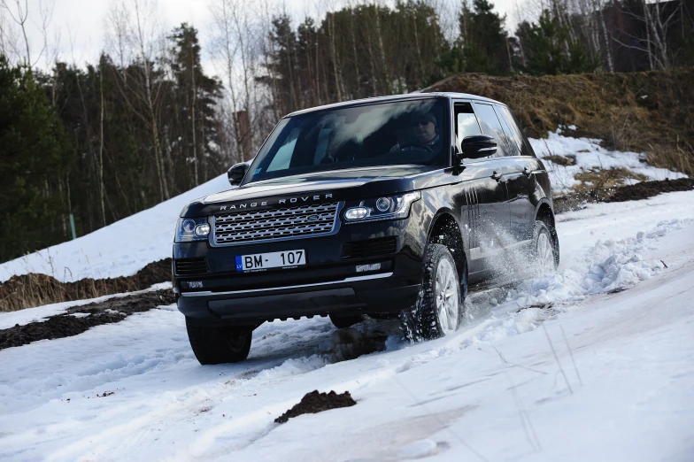 a black land rover is driving in the snow
