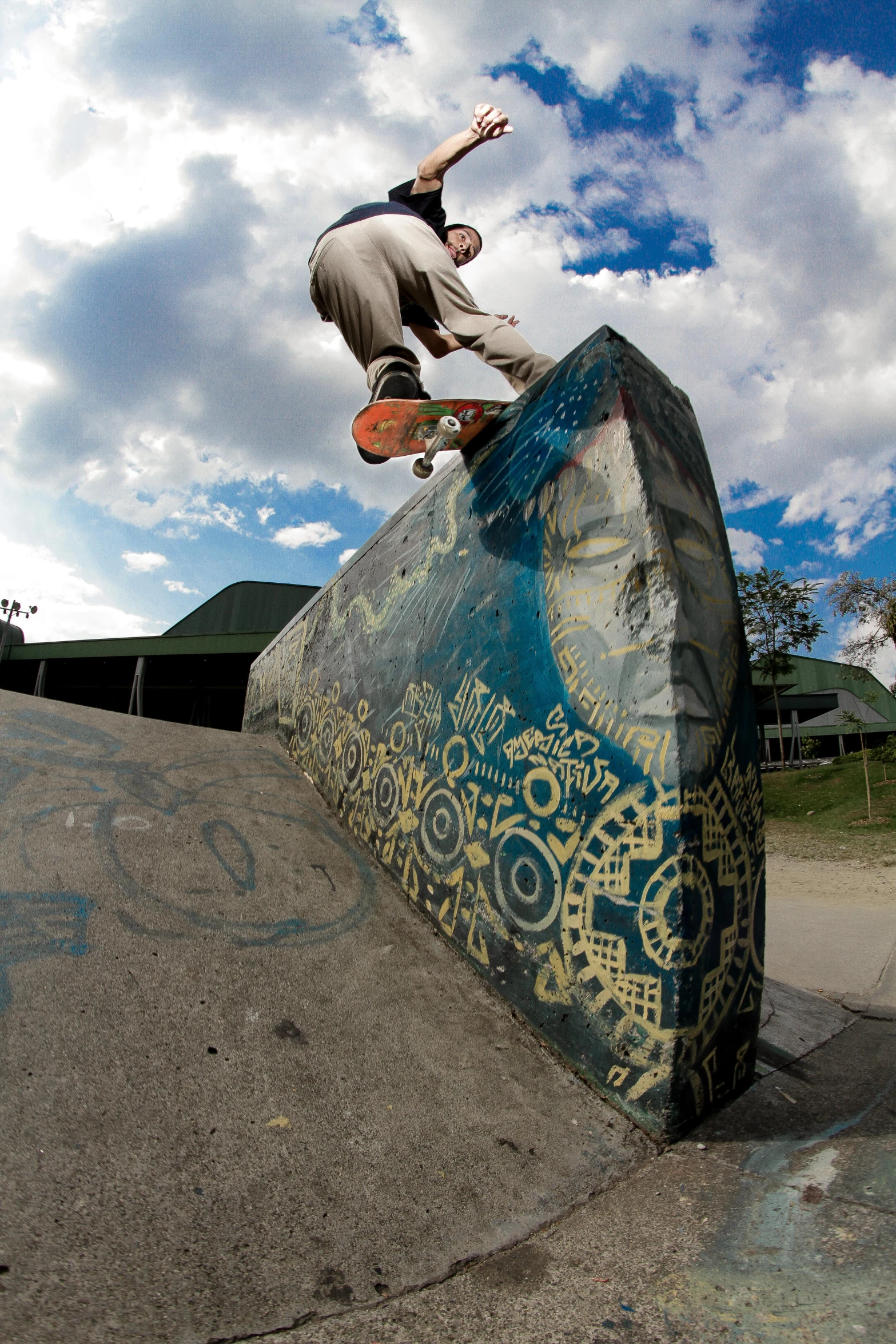 a man riding a skateboard over a blue rock