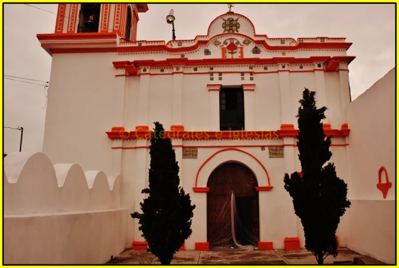 an old, white building with orange trim