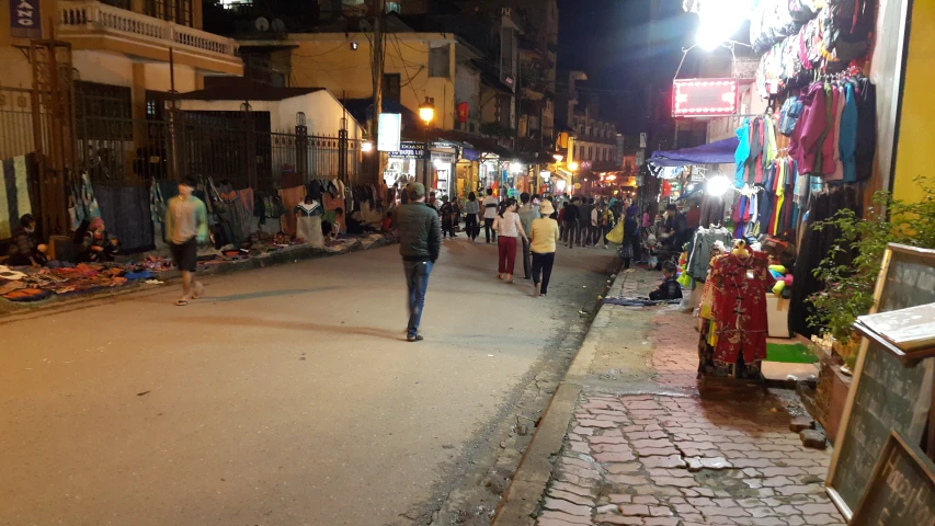 a man walks through the street as people watch from the sidewalk