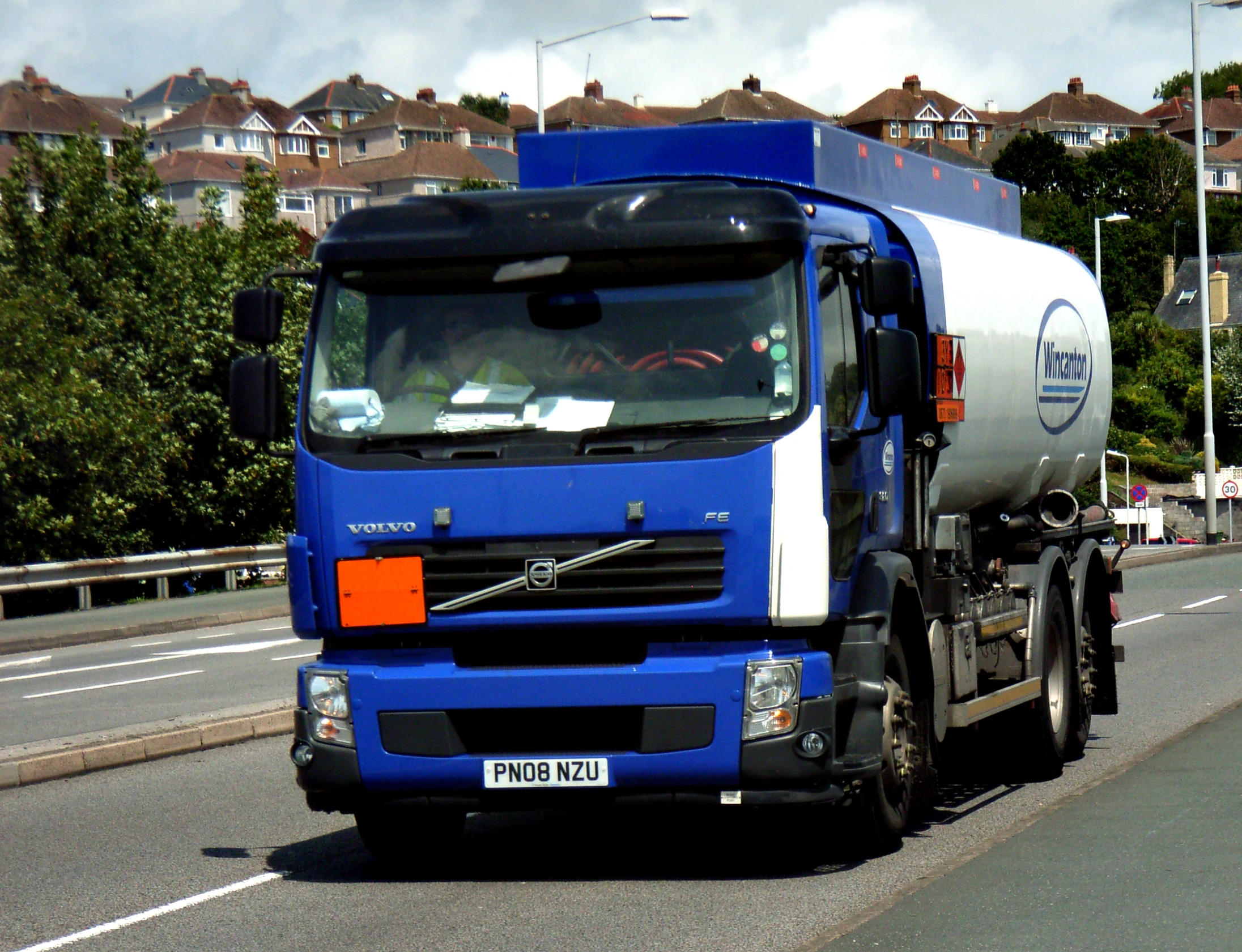 a blue and white truck driving down a street