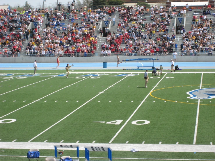 several people are standing on a field of green grass