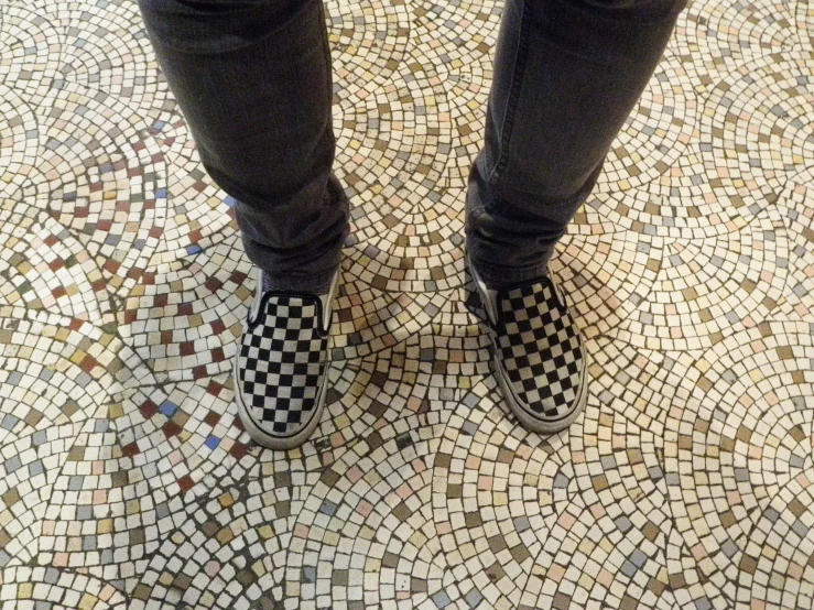 person standing on the ground with some checkered shoes
