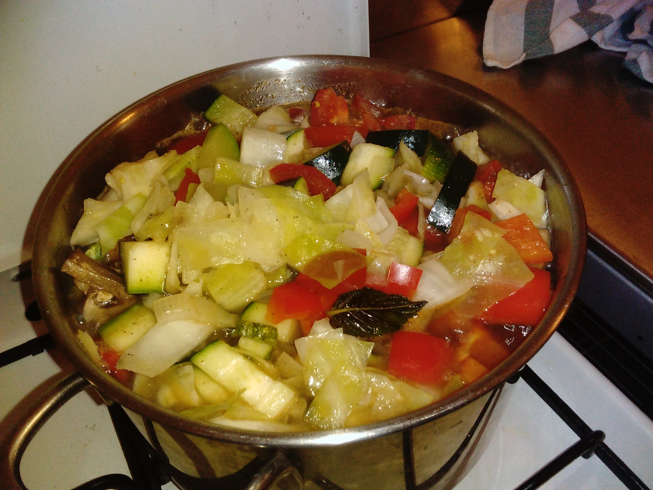 the pan has vegetables in it on the stove