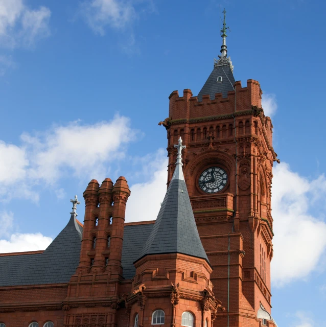 a large red brick building has a black clock tower