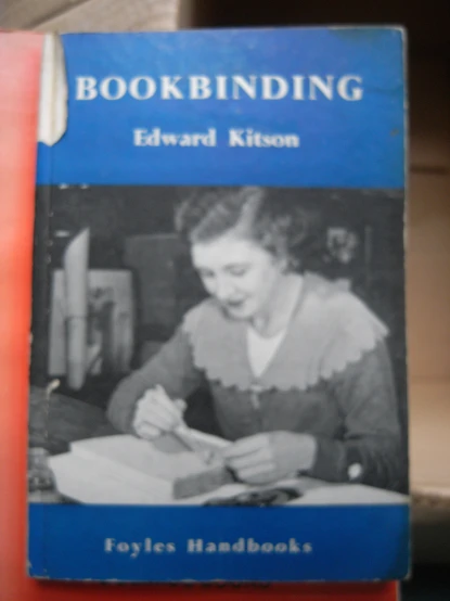 the bookbinding, by edward kison is being held in front of a stack of books