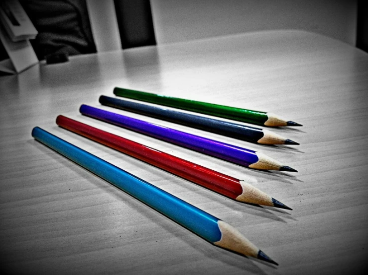 several colored pencils are lined up on a table