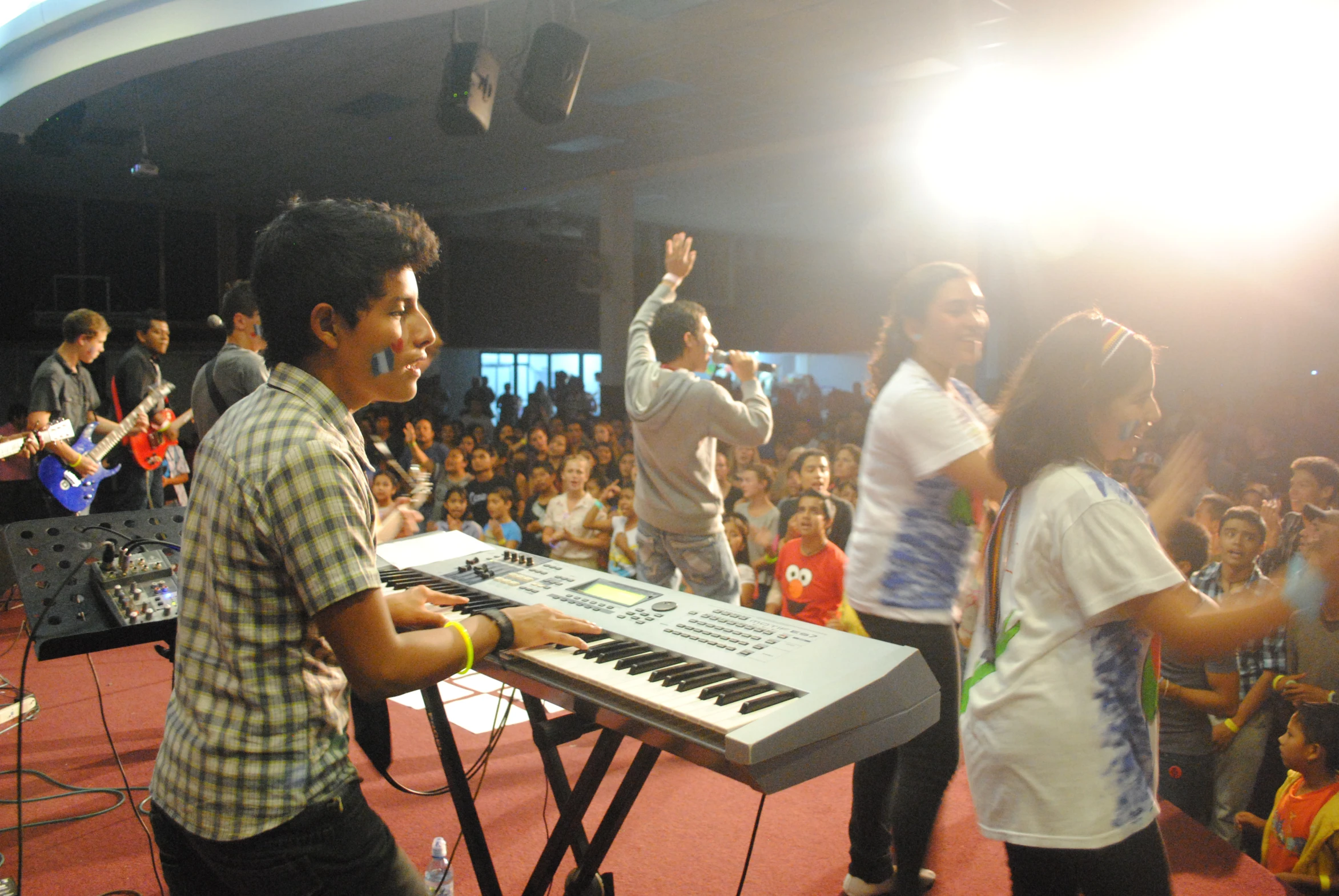 there are people standing by the keyboard on the stage