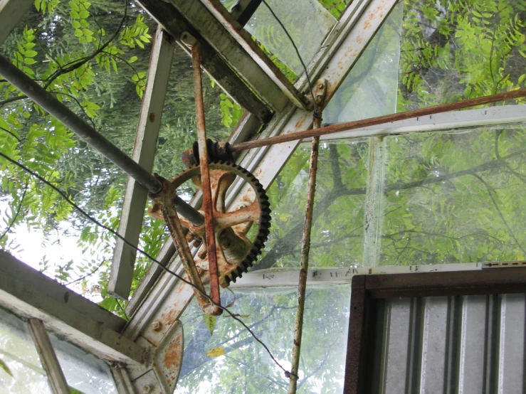 inside view of an old abandoned greenhouse with metal gear