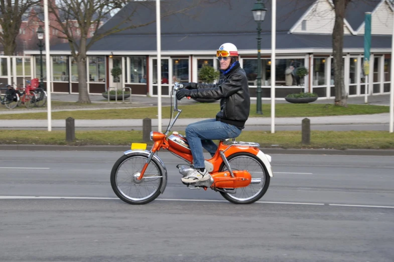 a person riding an orange bike with a white helmet