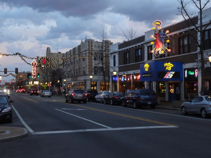 a busy city street at dusk with buildings in the background