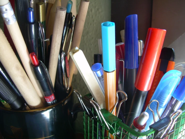 a small metal container filled with lots of pen and pencil