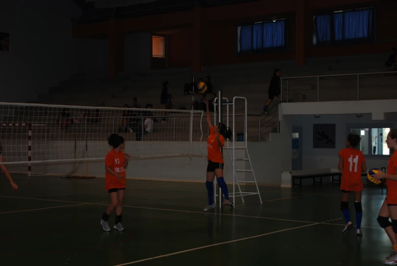 two women play soccer on an indoor court