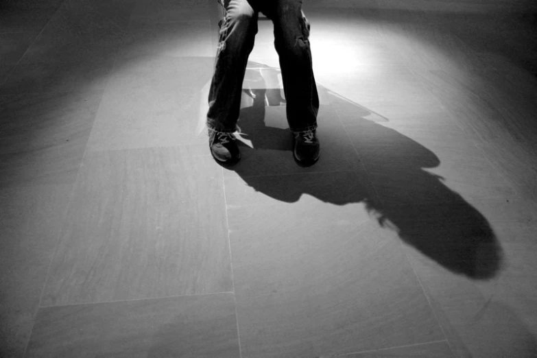 a skateboarder in a black jacket and jeans sits on a skateboard