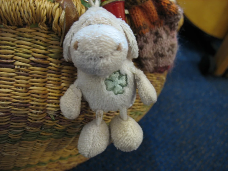 a stuffed animal with two clovers attached to a basket