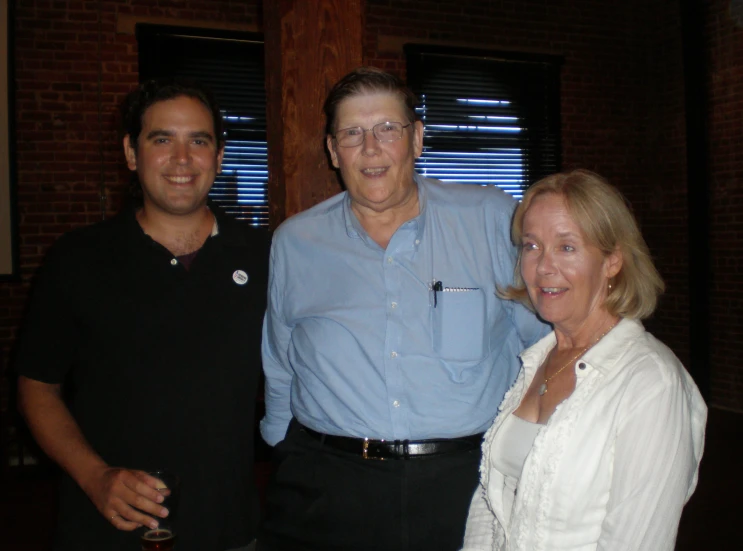 three smiling people are posing together while posing for the camera