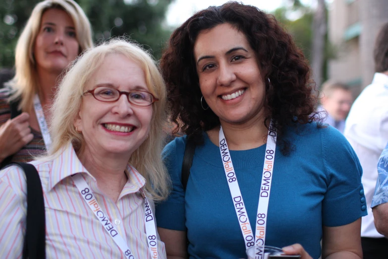 two women with lanyards and smiling for a picture