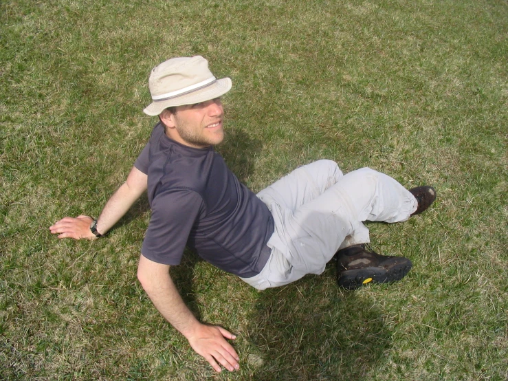 a man laying on the grass in a hat