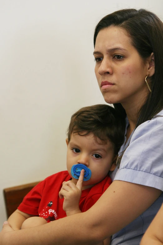 a woman sitting down while holding a young child