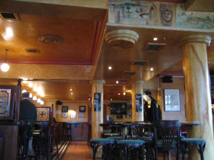 several stools at tables in a bar with wallpaper