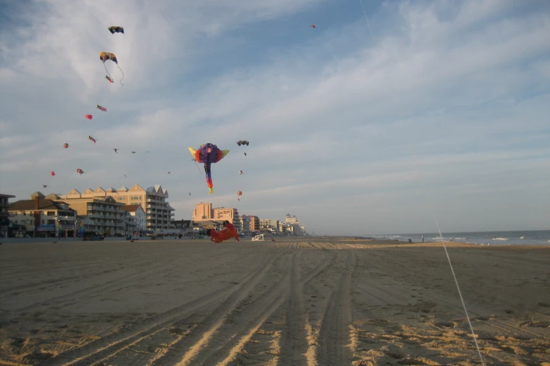 an array of different colorful kites in the sky above the sand