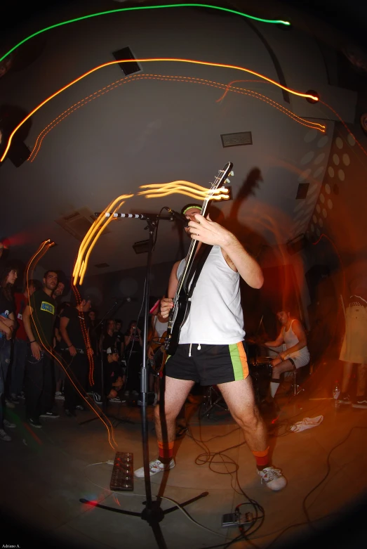 people are watching a man sing and playing instruments in front of a crowd