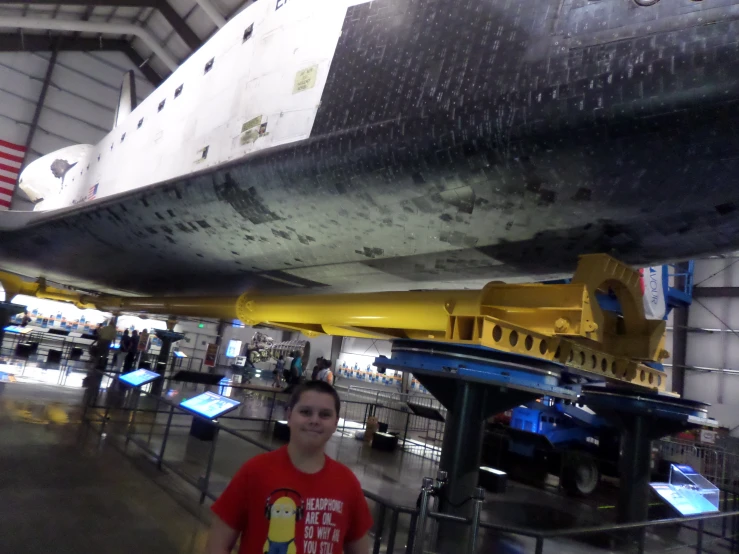 a young man standing in front of a space shuttle