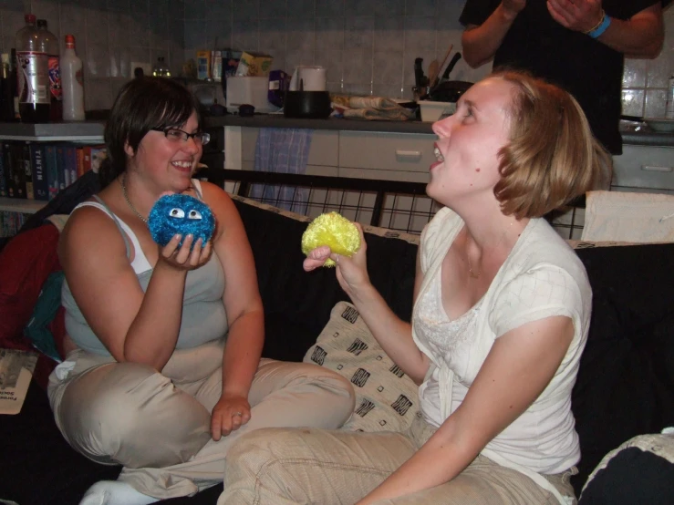 a couple of women sitting on top of a couch