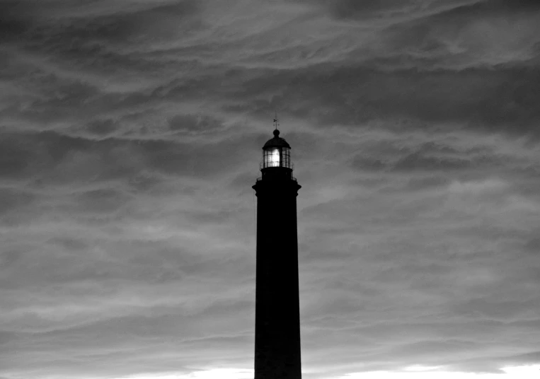 a clock tower stands in the midst of clouds