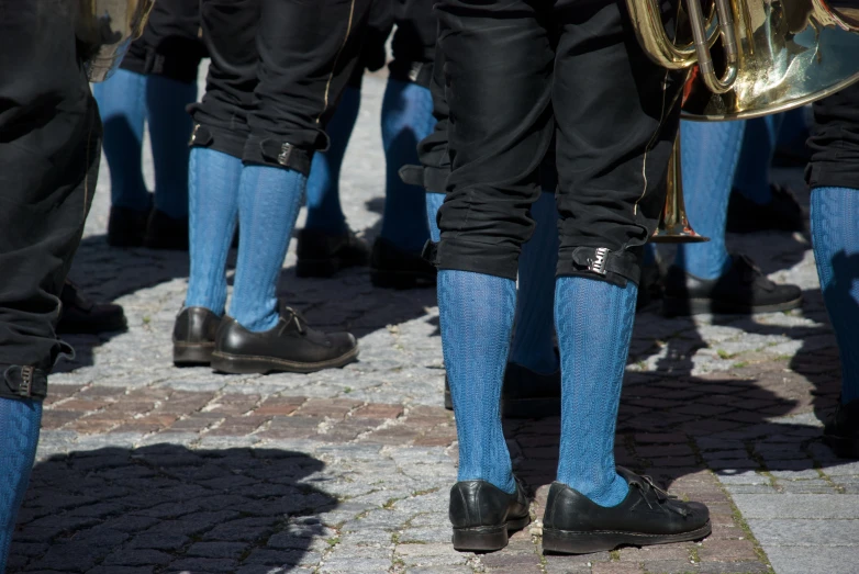 some men are marching in blue and black uniforms