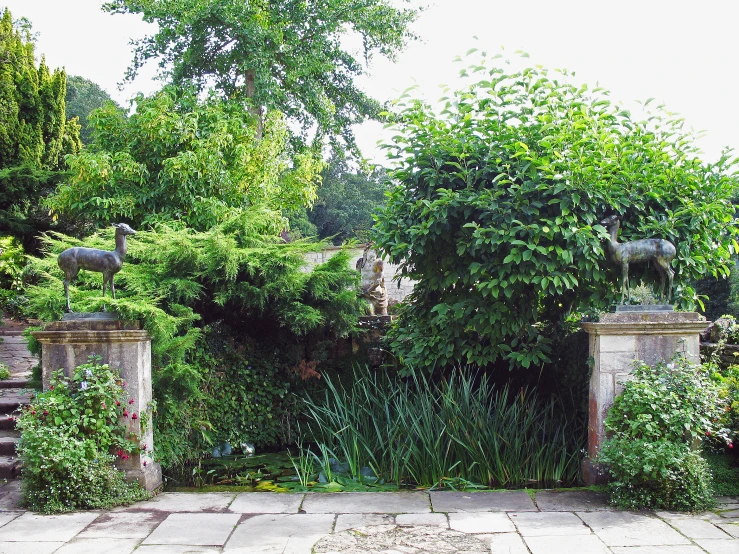 two statues on posts on the side of a brick building