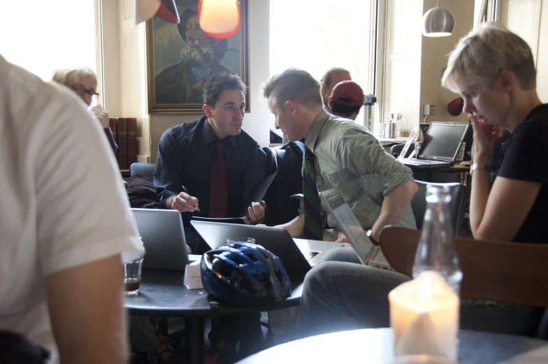 group of people at table with laptop computers in open room