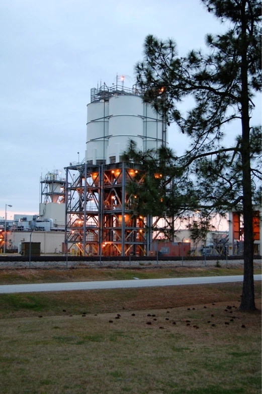 a large water tank sitting behind a tree on a field