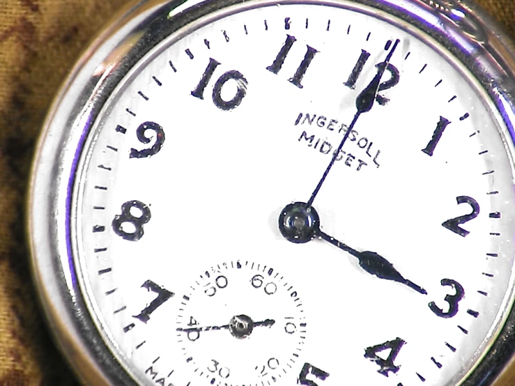 a closeup of a small silver pocket watch