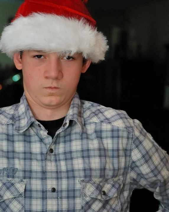 a boy wearing a santa hat makes a face