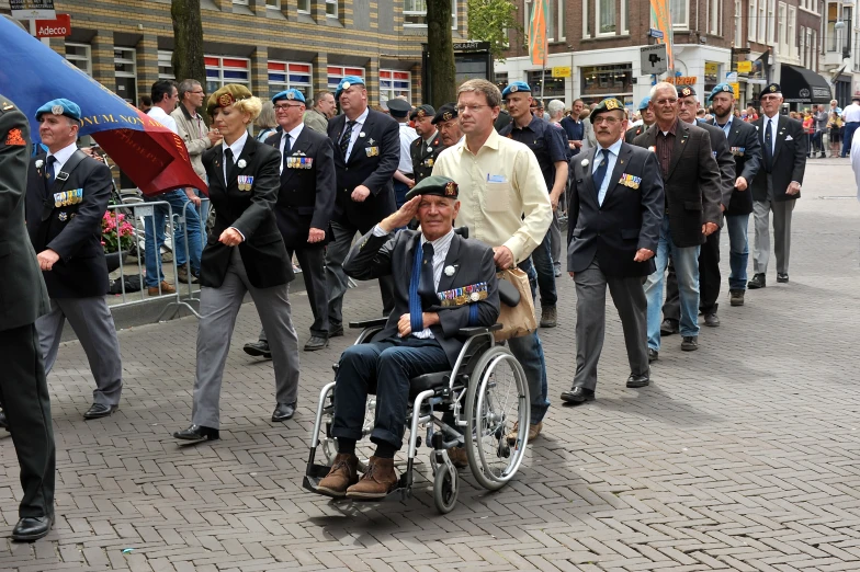 a man sitting on top of a wheel chair next to another man