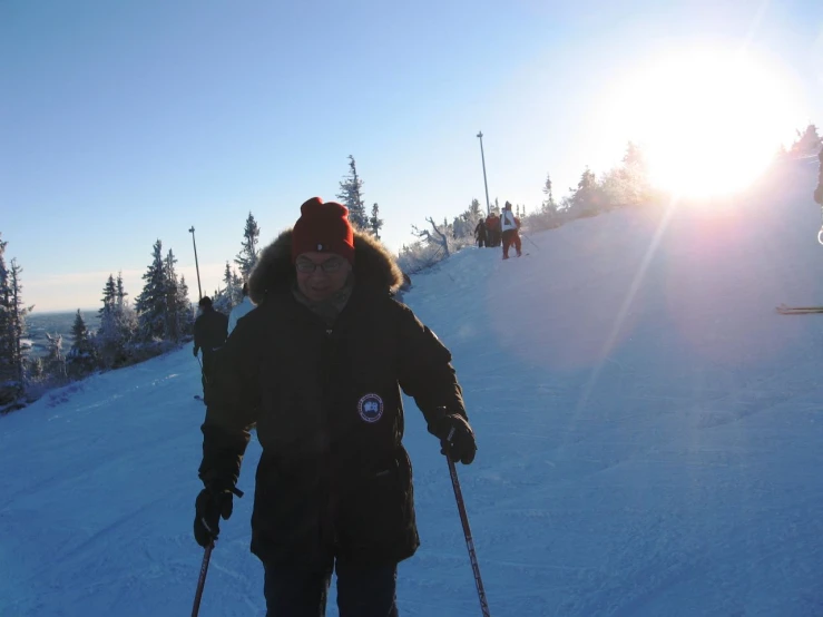 the skier is headed toward the sun in his gear