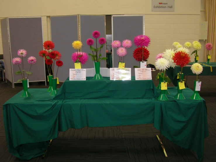 flowers are arranged on green cloths in front of a table