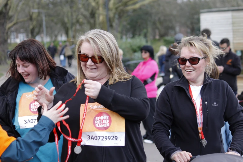 three women holding up orange signs and string