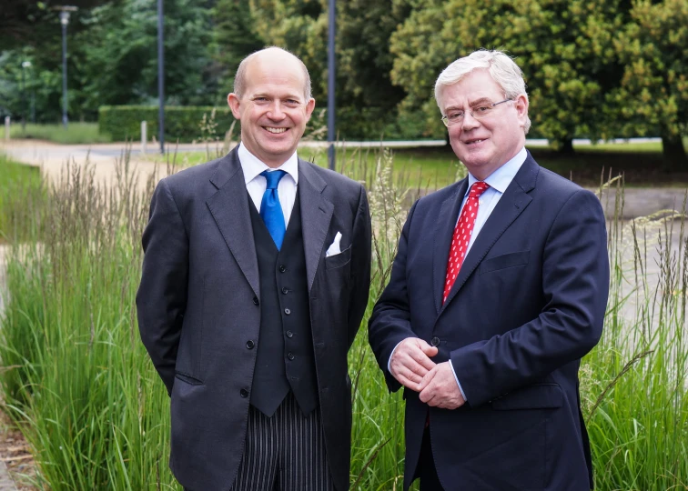 two men standing in front of some tall grass