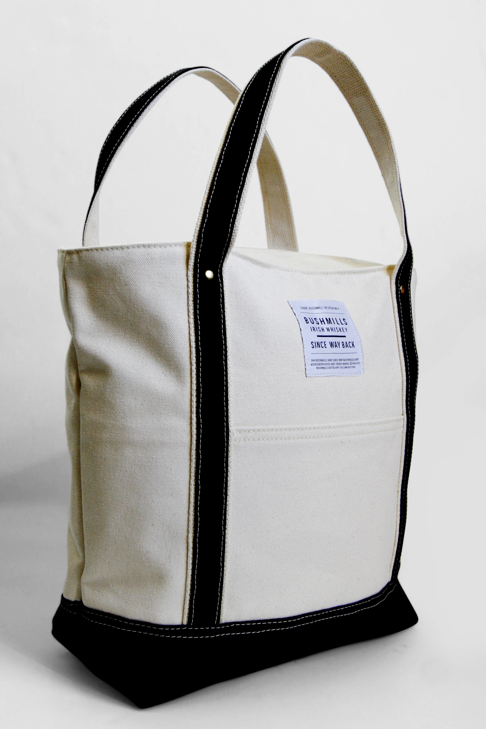 a black and white tote bag is open and shows the strap