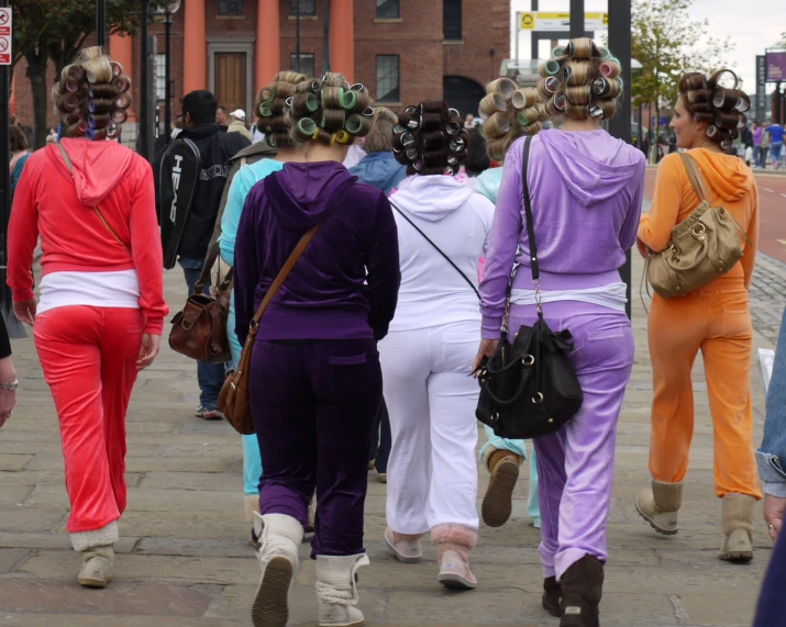 a group of women walking down the sidewalk