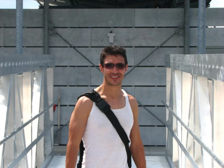 young man walking on walkway with backpack to his back