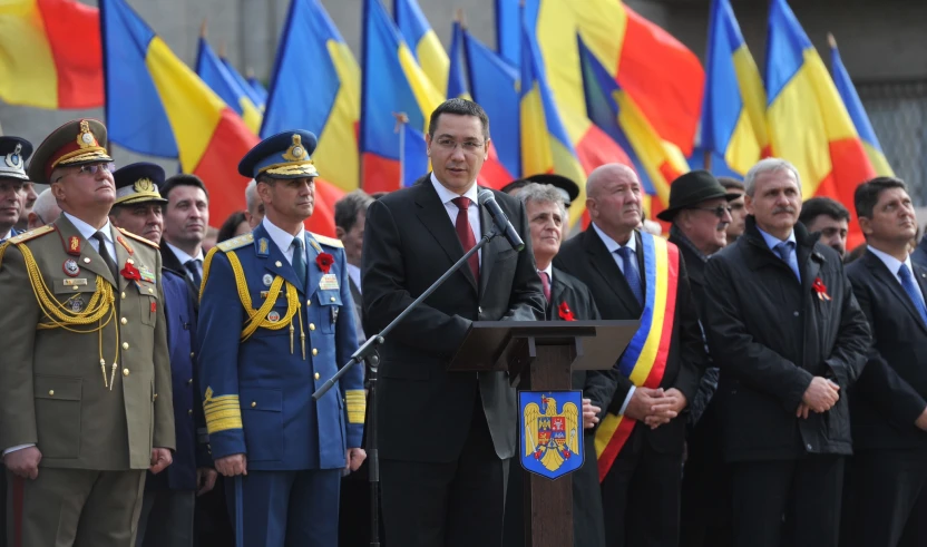 a man standing at a podium in front of a group of men