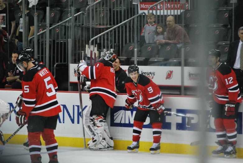 a group of people in red and black playing hockey