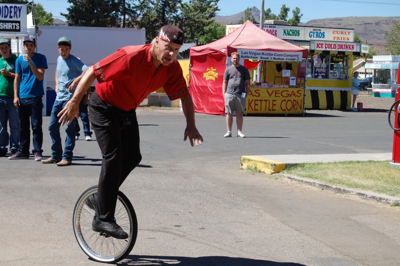 a man riding a unicycle on top of a street